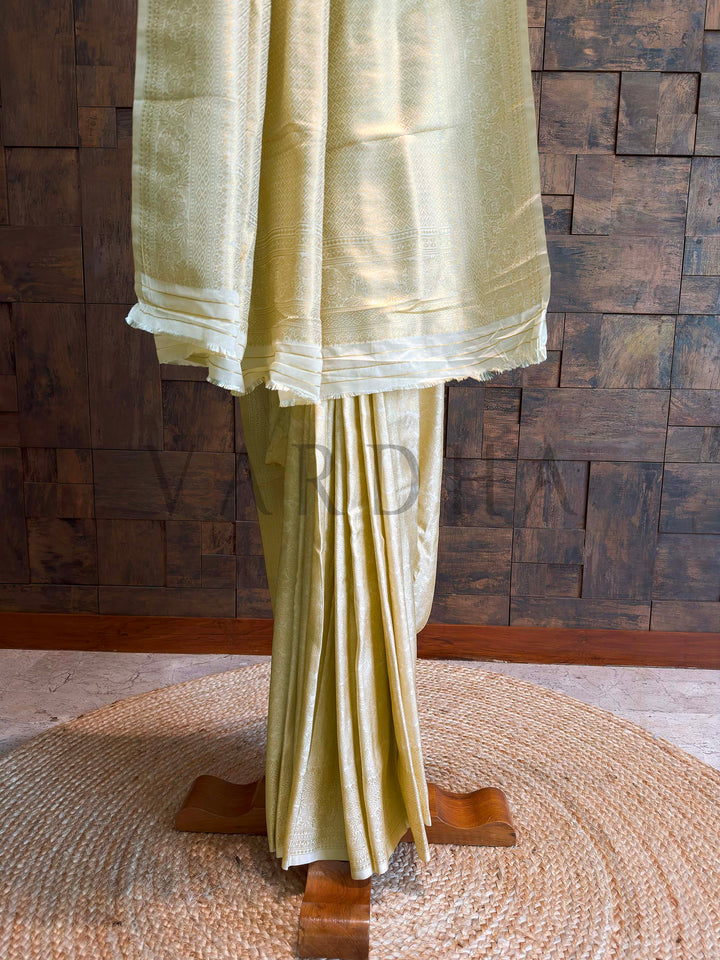 Lower half view highlighting diamond brocade border in gold zari over ivory base with neatly stacked pleats and soft sheen