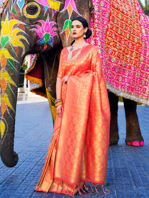Coral orange kanjivaram silk saree with rich golden zari motifs, styled for wedding day elegance. Glossy bridal coral saree in silk with traditional motifs, perfect for receptions and mandap moments.