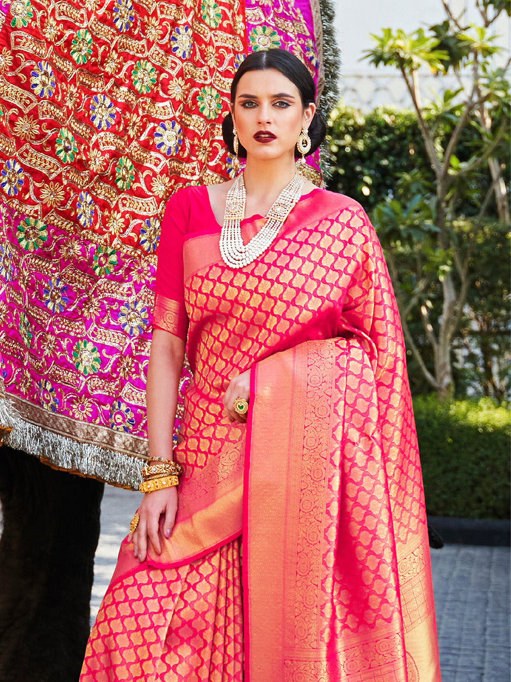 Magenta–Gold kanjivaram silk drape styled for receptions, varmala, and wedding rituals. Glossy silk base in Magenta–Gold with gold accents and woven border flair.