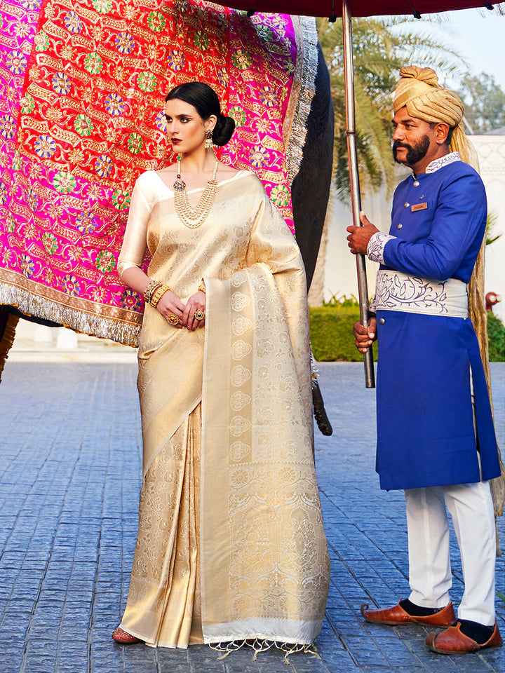 Ivory–Champagne Gold bridal kanjivaram saree with gold zari motifs and festive pallu styling. Classic Ivory–Champagne Gold silk saree featuring woven jacquard zari and traditional pallu elegance.