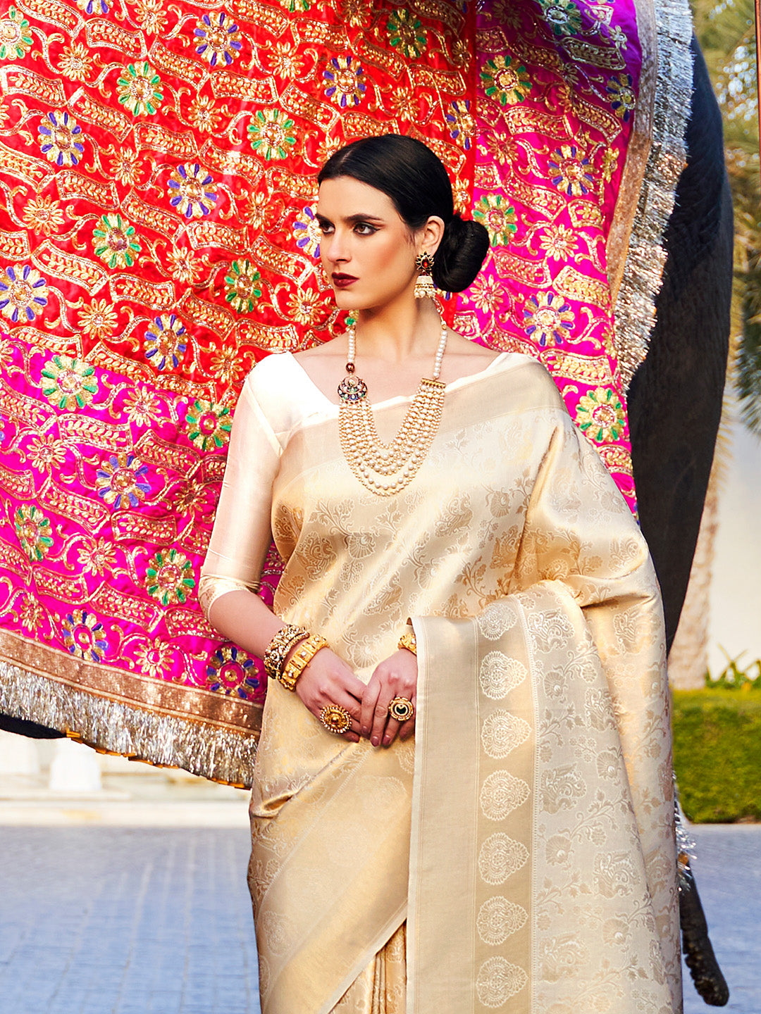 Ivory–Champagne Gold kanjivaram silk drape styled for receptions, varmala, and wedding rituals. Glossy silk base in Ivory–Champagne Gold with gold accents and woven border flair.
