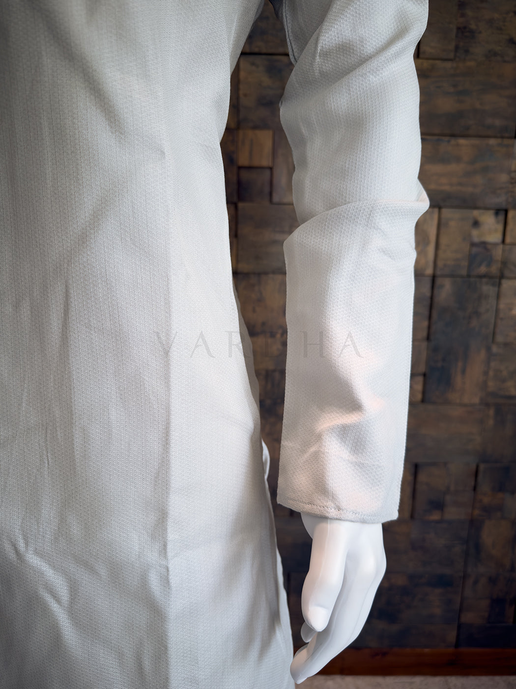 Grey lab Kurta on a wooden background. Close-up of a designer Light Grey kurta showing the extended chest placket with traditional fabric button loops and rustic wooden-style buttons.