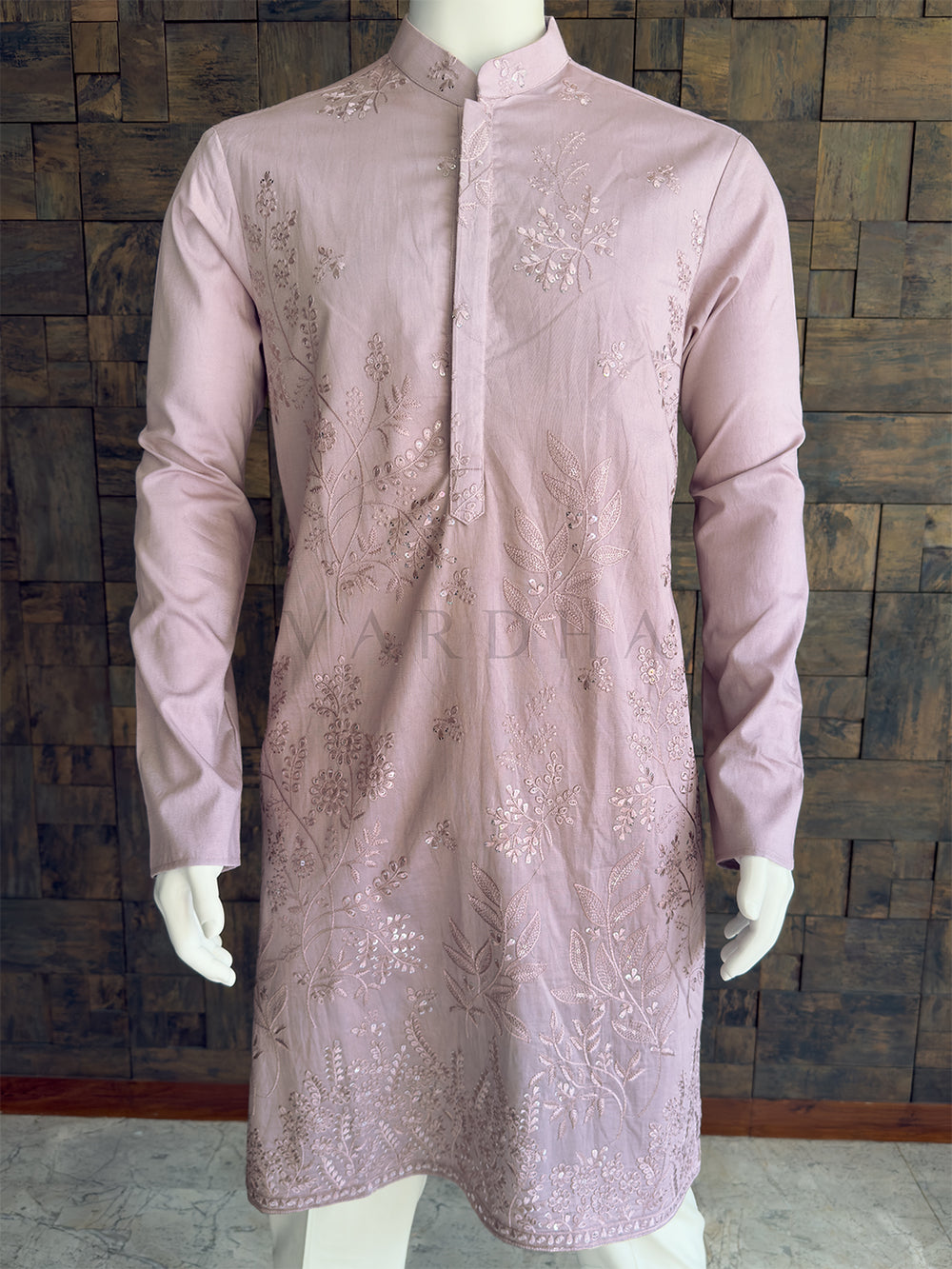 Light purple embroidered kurta on a mannequin against a wooden paneled wall. Close-up of the pastel lavender men's festive kurta showcasing the intricate vine and leaf threadwork with shimmering sequins and a clean concealed placket.