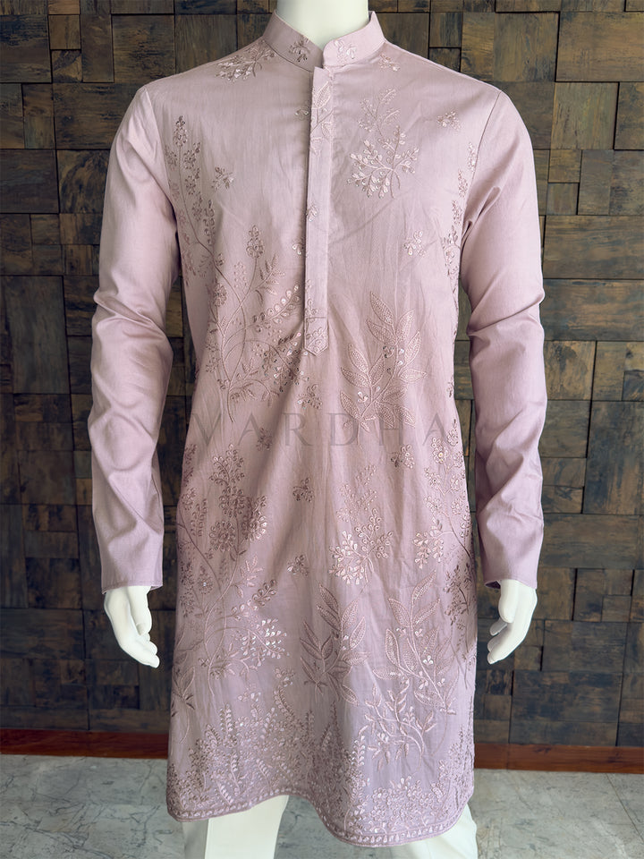Light purple embroidered kurta on a mannequin against a wooden paneled wall. Close-up of the pastel lavender men&