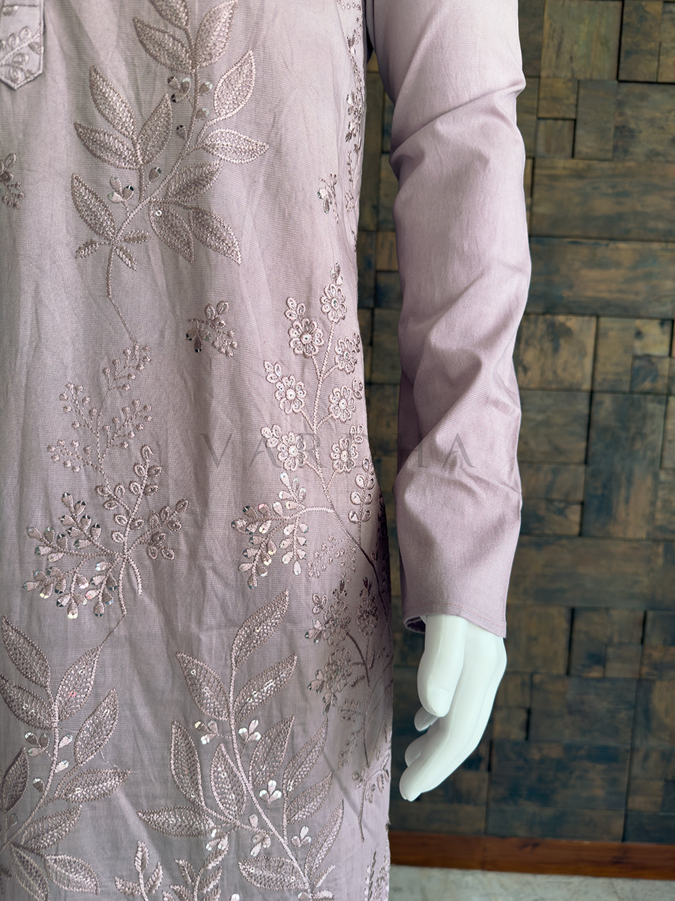 Mannequin wearing a light purple outfit with floral embroidery against a wooden background. Side angle of the beautifully draped lilac viscose kurta for men, highlighting the exquisite floral embroidery on the lower half and premium tailored fit.