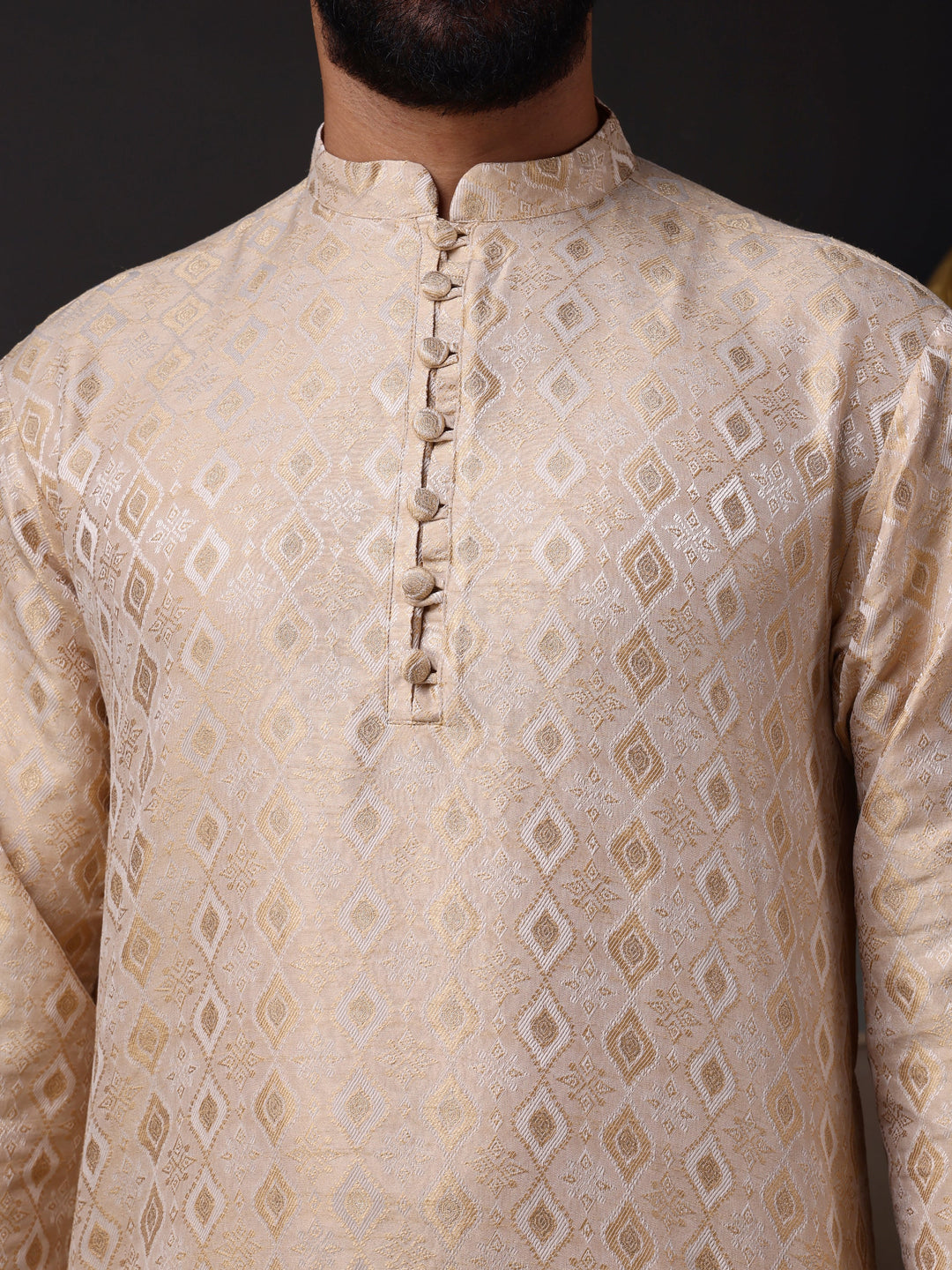 Full view of a model in a luxurious beige-gold jacquard kurta and white pajamas, exuding festive elegance