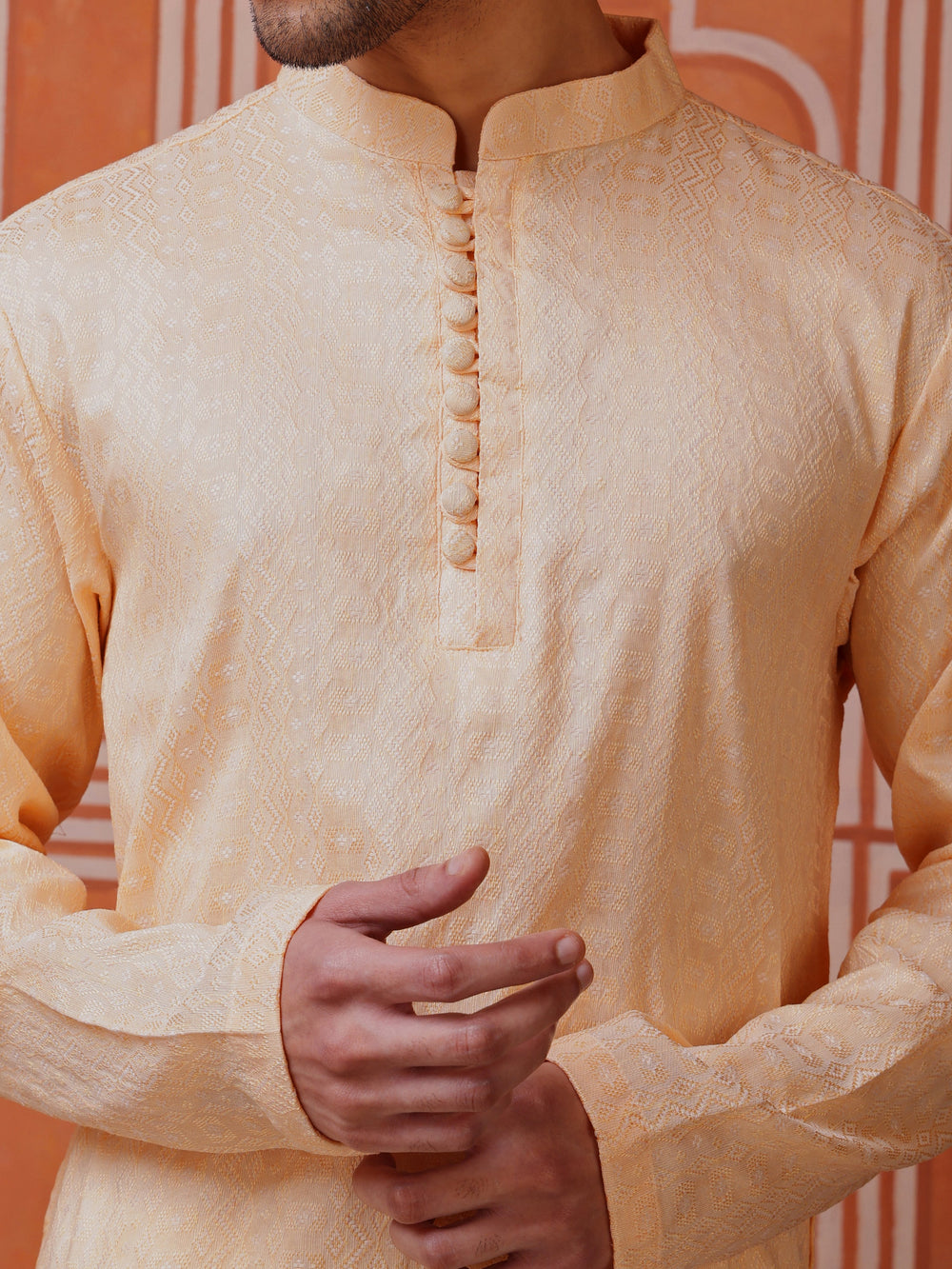 Elegant peach kurta for men featuring a subtle diamond pattern jacquard fabric and button placket