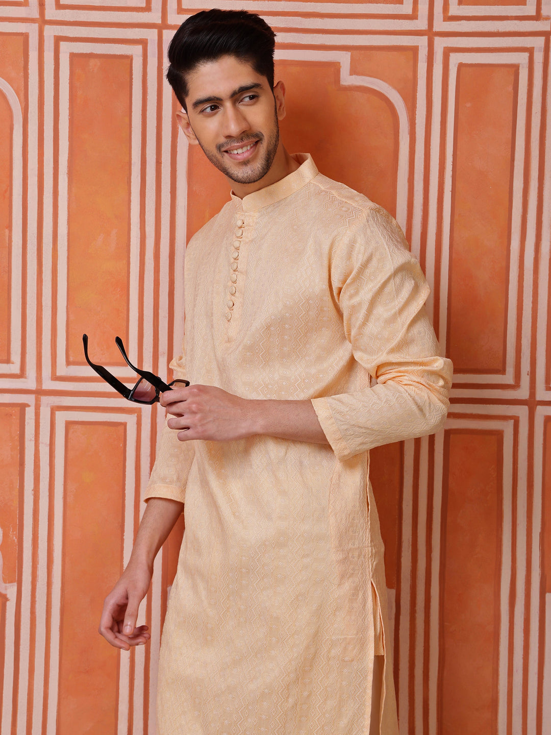 Full view of a man wearing a peach silk blend kurta and white pyjamas, ideal for festive occasions