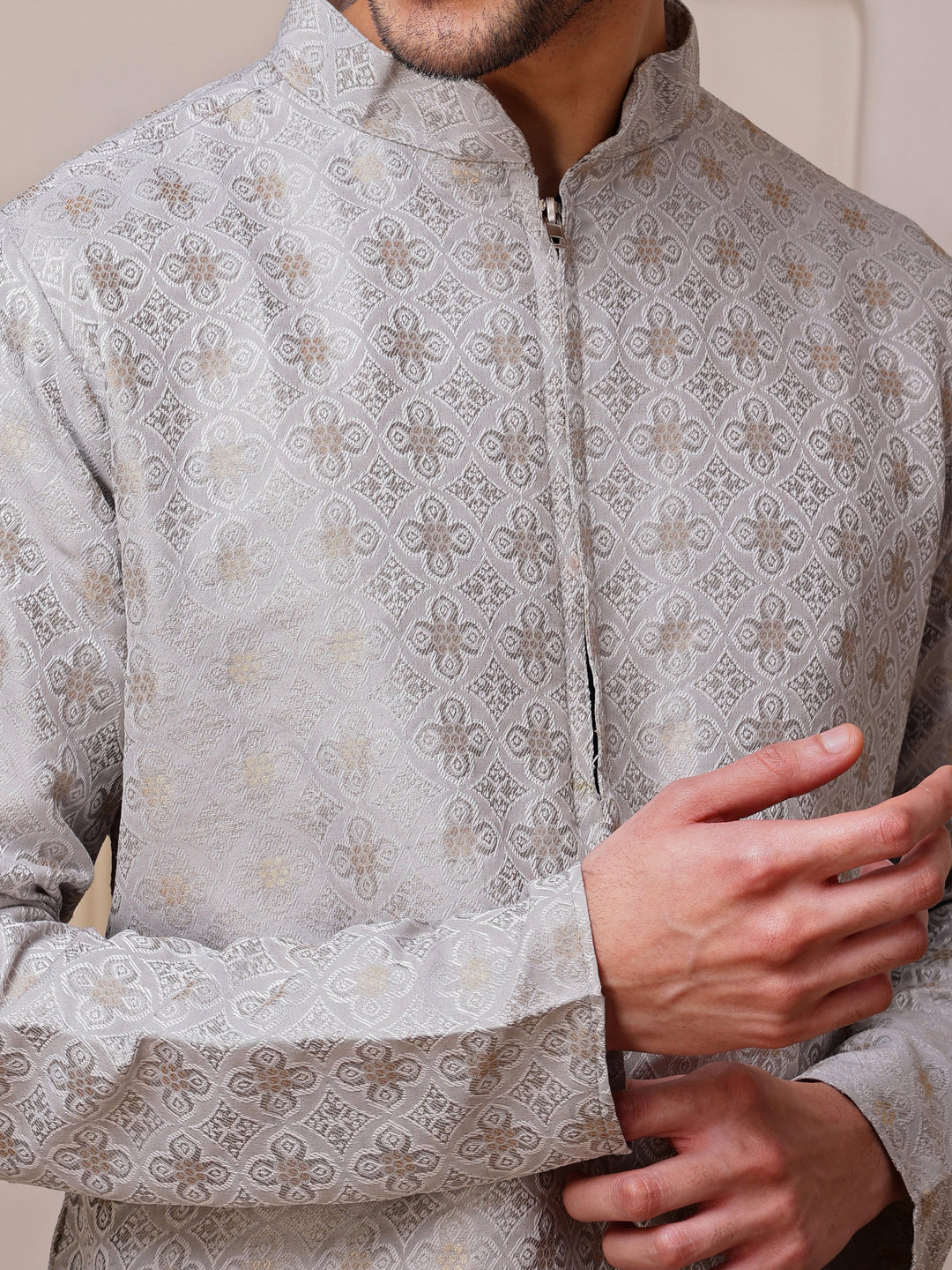 Full view of a man wearing a sophisticated light grey kurta with gold weave and a concealed zipper placket