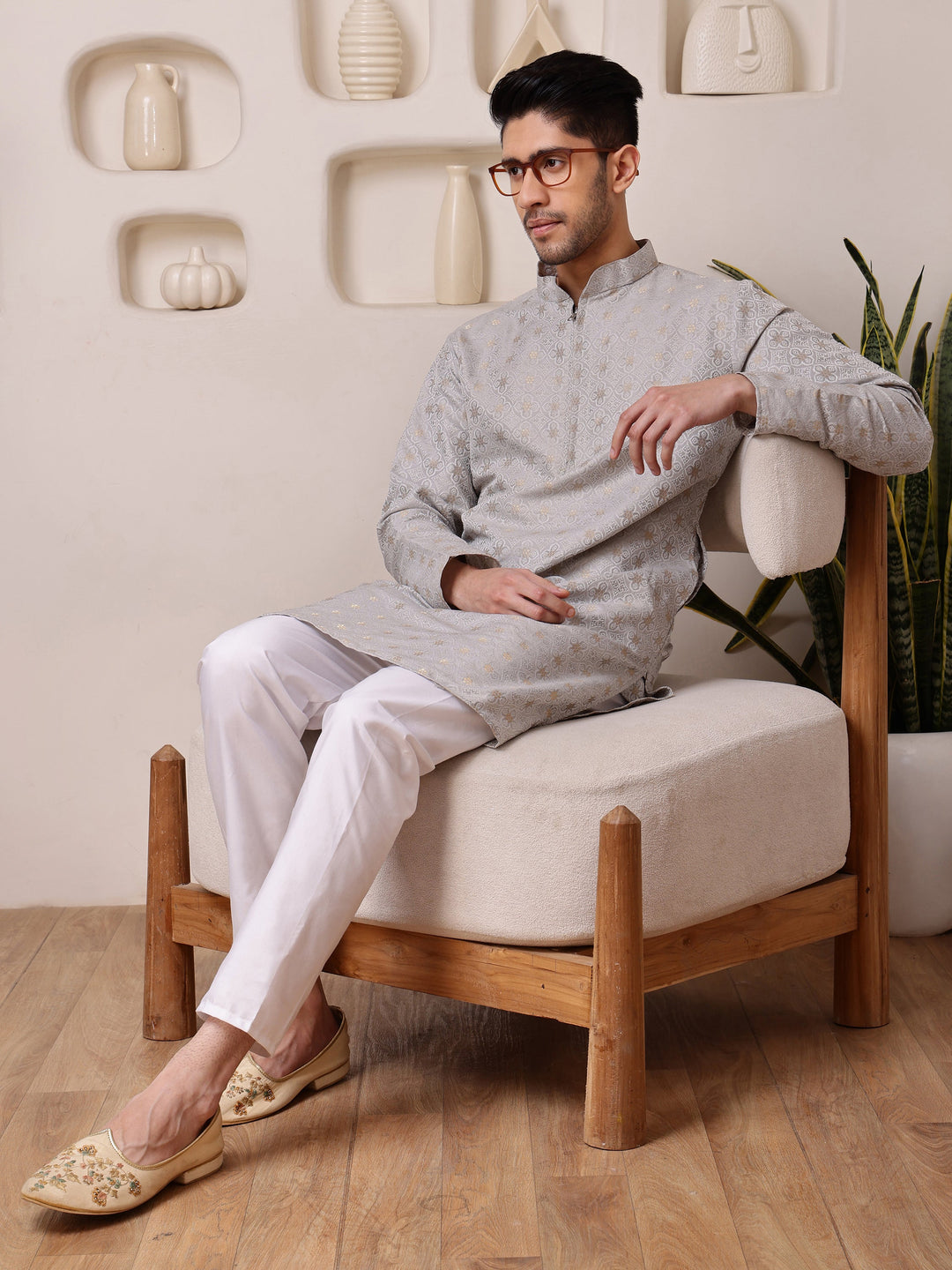 <br\ crockery/vases on shelf in background >---<br>Grey mandarin collar kurta for men with golden woven designs, ideal for a refined festive appearance
