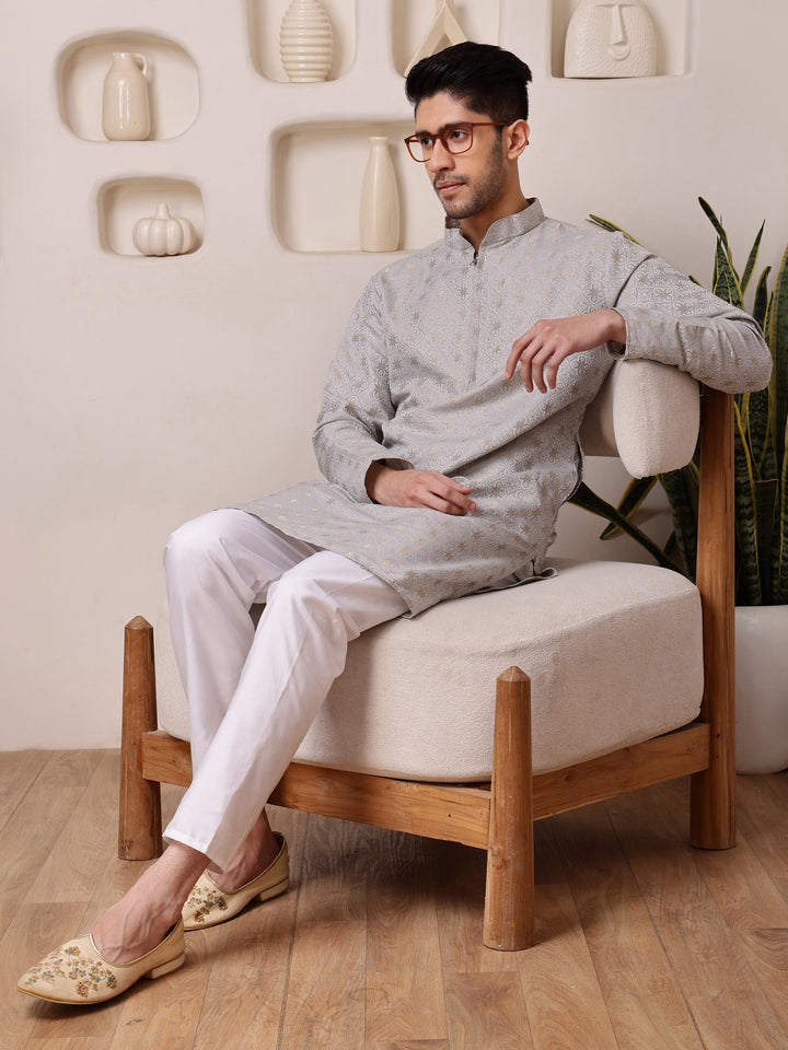 <br\ crockery/vases on shelf in background >---<br>Grey mandarin collar kurta for men with golden woven designs, ideal for a refined festive appearance