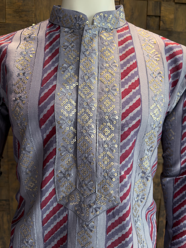 Traditional embroidered garment with red and blue stripes on a wooden background