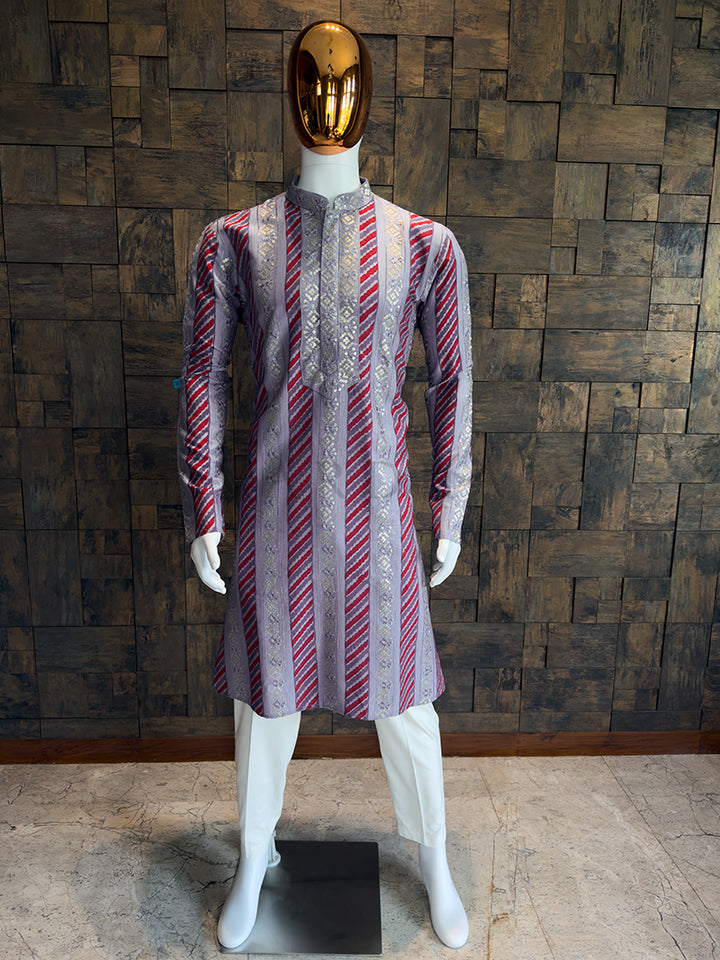 Mannequin wearing a patterned kurta against a wooden paneled wall.