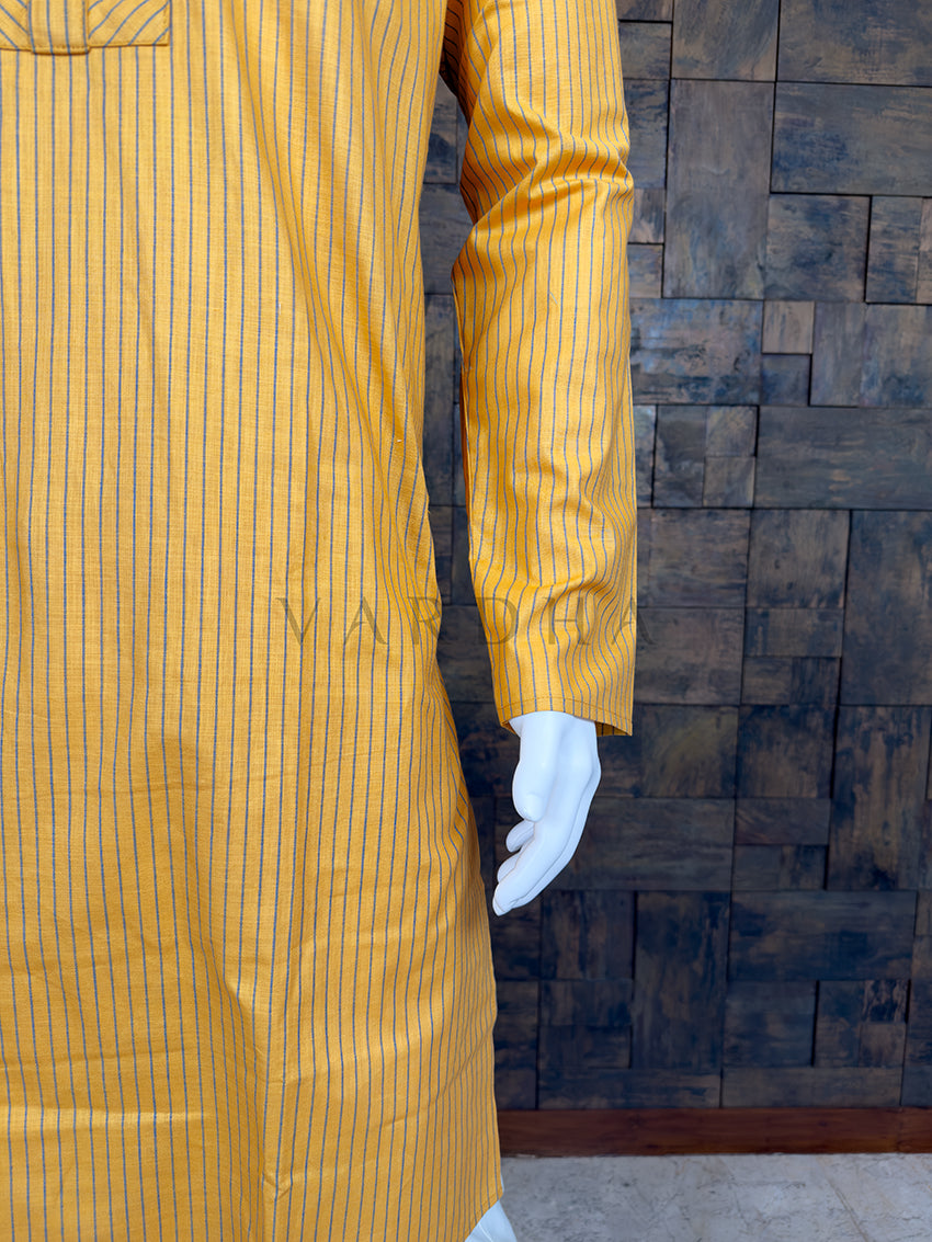 Yellow striped shirt on a mannequin against a wooden paneled wall.