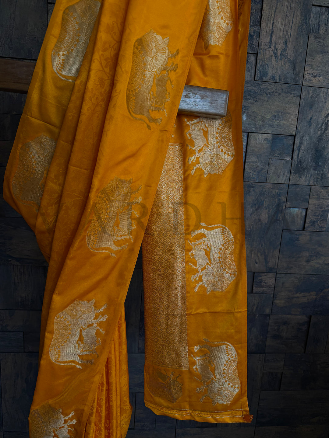 Festive satin saree in deep orange hue with intricate zari woven elephant pattern.

Elegant mustard-orange satin saree with traditional elephant design and silky finish.

