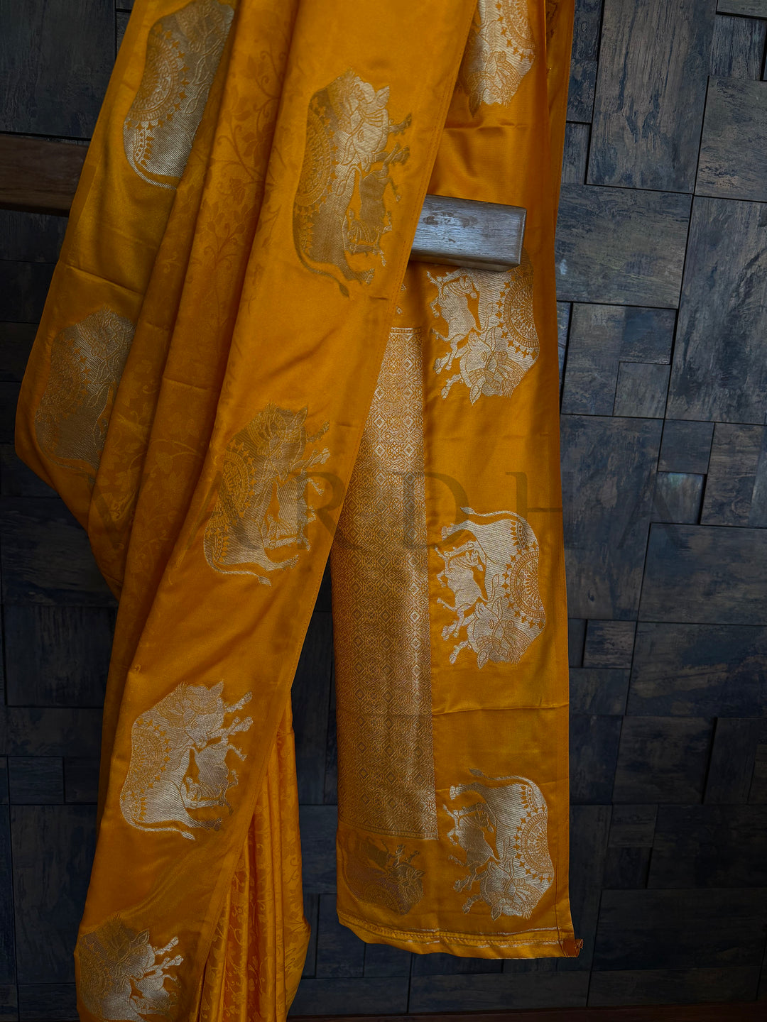Women’s partywear satin saree in mustard orange with golden woven detailing.

