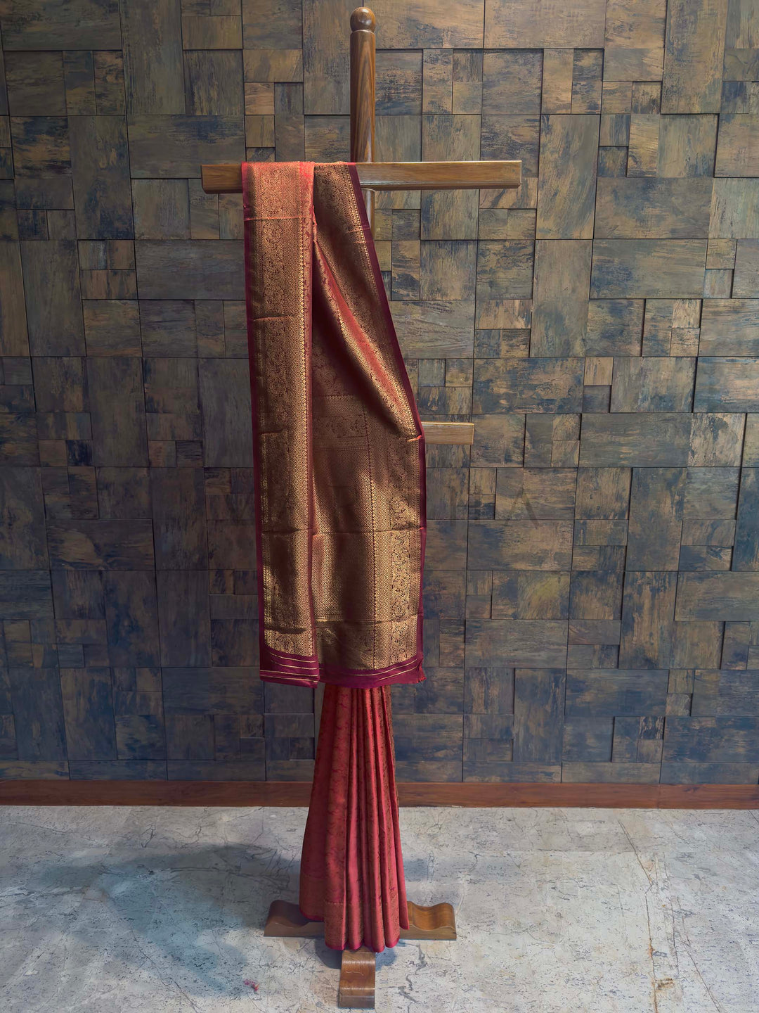 Maroon Golden Zari Kanjivaram Silk Saree House of Vardha. Beautifully draped copper-toned silk saree highlighting fine gold woven patterns and a striking rich pallu by House of Vardha. We offer Ready to wear, Pre drape service, Saree Add on, Custom Stitched Blouse, Fall and Edging, Gift Packaging at Complimentary Price!