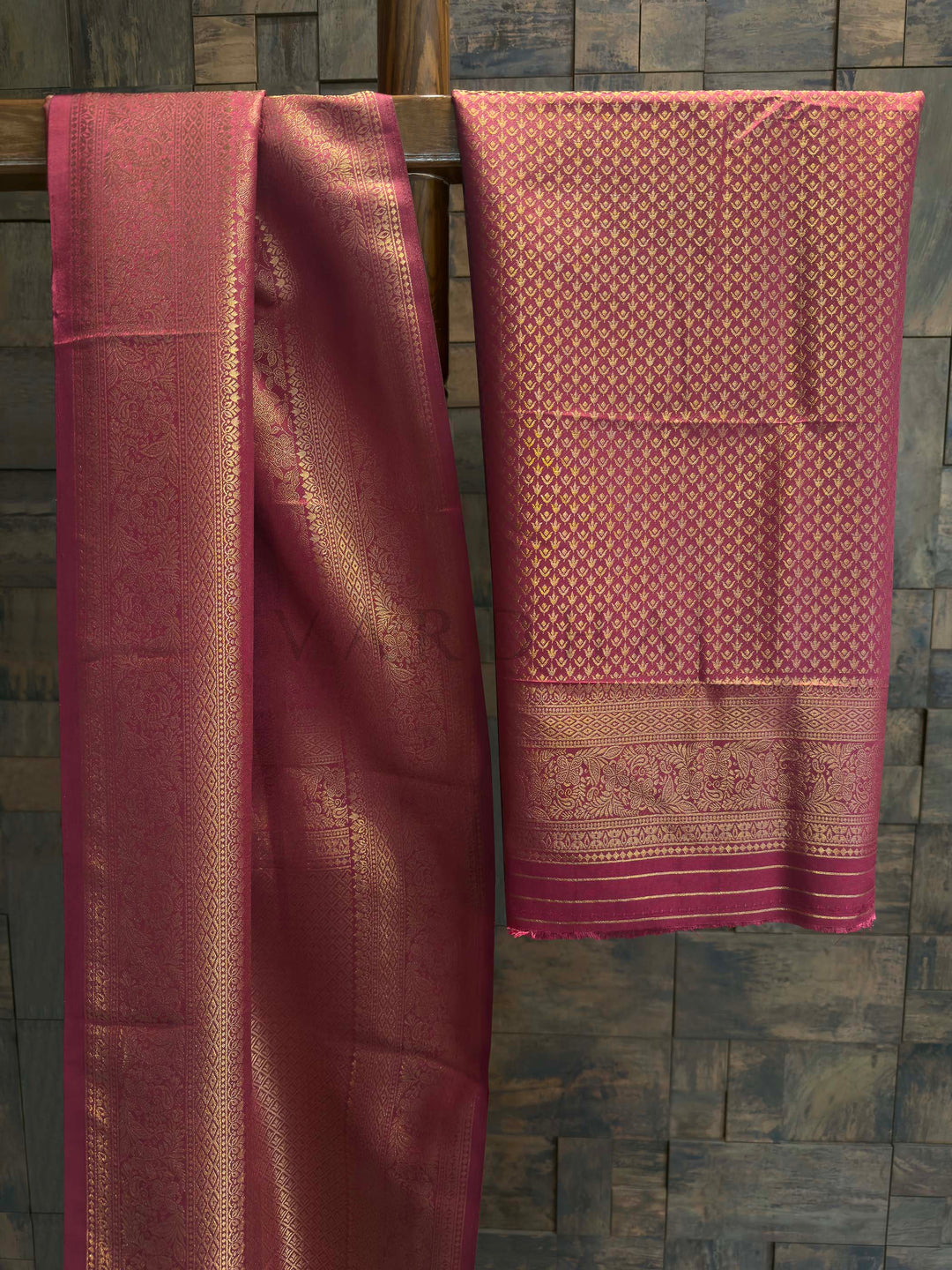 Maroon Golden Zari Kanjivaram Silk Saree House of Vardha. House of Vardha traditional maroon and gold woven silk saree displaying a detailed geometric zari border against a textured backdrop. We offer Ready to wear, Pre drape service, Saree Add on, Custom Stitched Blouse, Fall and Edging, Gift Packaging at Complimentary Price!