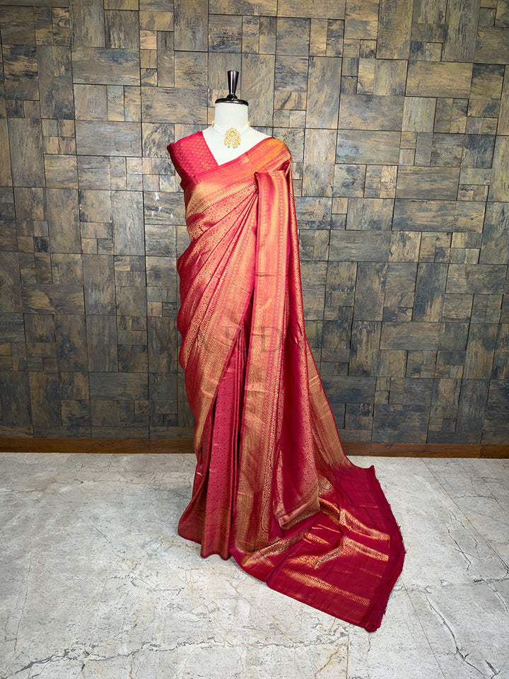 Maroon saree with gold patterns on a mannequin against a wooden paneled wall. House of Vardha Maroon Golden Zari Kanjivaram Silk Saree featuring heavy traditional gold woven motifs, elegantly draped on a mannequin. We offer Ready to wear, Pre drape service, Saree Add on, Custom Stitched Blouse, Fall and Edging, Gift Packaging at Complimentary Price!