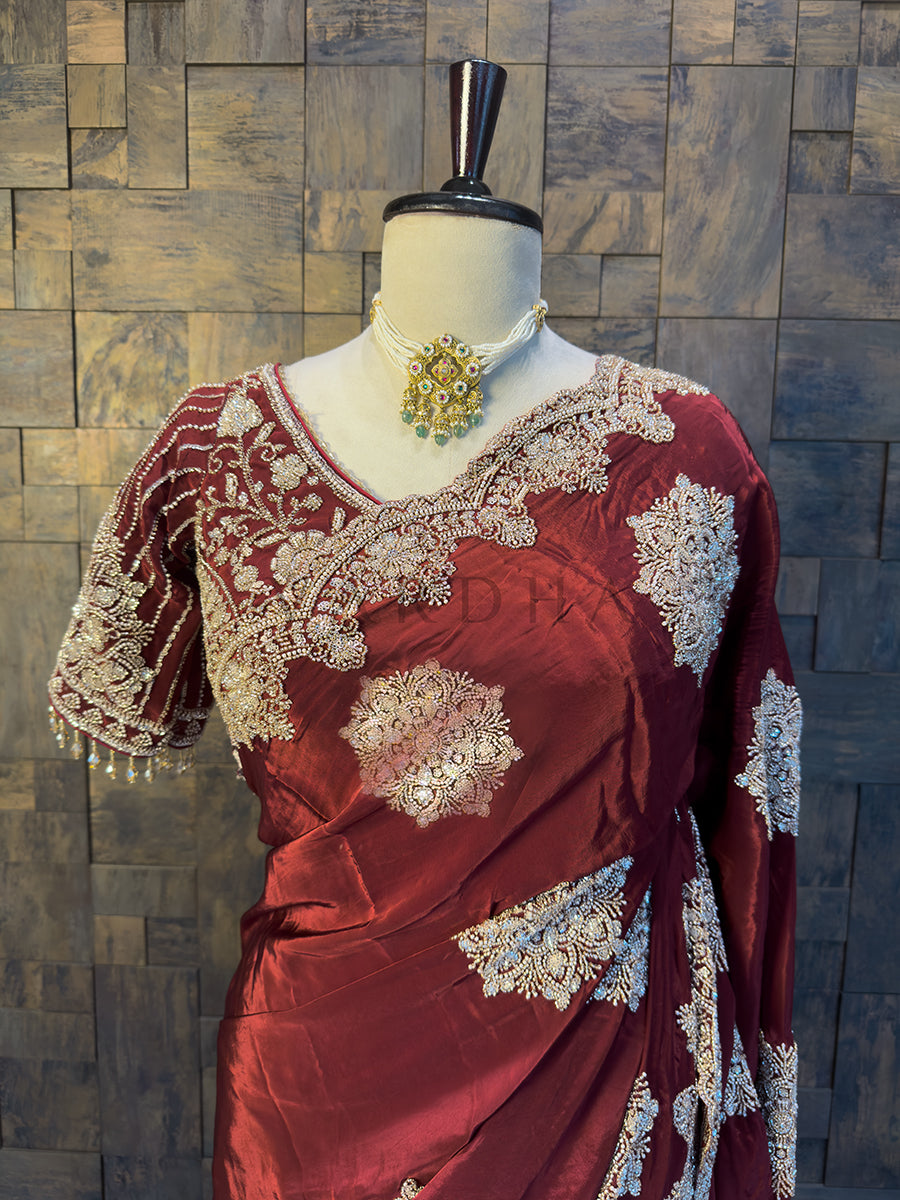 Designer Embroidered Blouse paired with Burgundy Crepe Saree. Close-up of the exquisite Silver Cutdana and Beads Handwork on a rich Maroon Satin Crepe Saree by House of Vardha. We offer Ready to wear, Pre drape service, Saree Add on, Custom Stitched Blouse, Fall and Edging, Gift Packaging at Complimentary Price!
