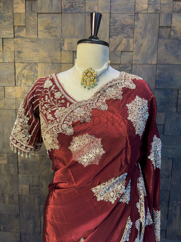 Designer Embroidered Blouse paired with Burgundy Crepe Saree. Close-up of the exquisite Silver Cutdana and Beads Handwork on a rich Maroon Satin Crepe Saree by House of Vardha. We offer Ready to wear, Pre drape service, Saree Add on, Custom Stitched Blouse, Fall and Edging, Gift Packaging at Complimentary Price!
