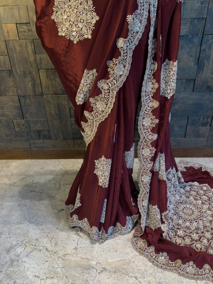 Close Up of Scalloped Silver Stone Work Border on Maroon Saree. Elegant deep Maroon Satin Crepe Saree from House of Vardha showcasing detailed Silver Cutdana hand embroidery along the border and pallu. We offer Ready to wear, Pre drape service, Saree Add on, Custom Stitched Blouse, Fall and Edging, Gift Packaging at Complimentary Price!