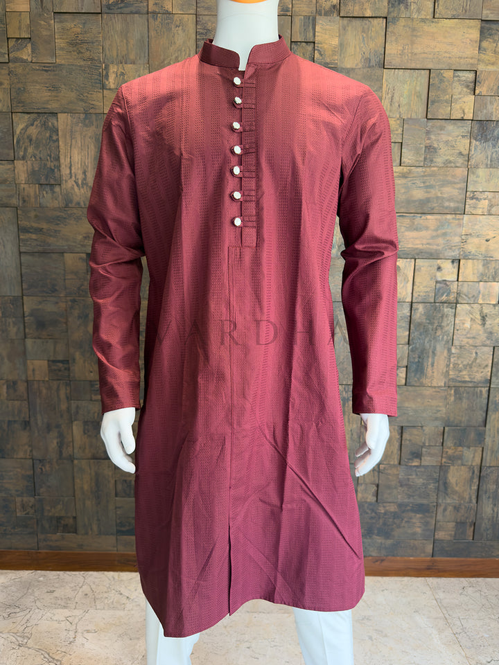 Maroon kurta on a mannequin against a wooden paneled wall. Premium breathable Maroon cotton kurta showcasing a crisp vertical micro-stripe finish and meticulously structured modern tailoring.