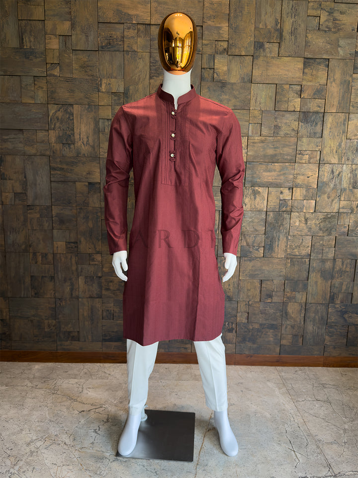 Maroon kurta on a mannequin against a wooden paneled wall. bold, deeply saturated Maroon Deep Burgundy long kurta. The rich, traditional color makes this an absolute staple for the festive season, guaranteeing high performance for evening weddings, Sangeet nights, and major cultural celebrations.