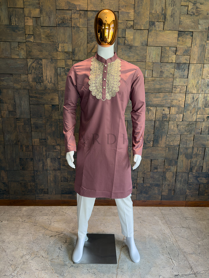 Mannequin wearing a mauve kurta with lace details against a wooden paneled wall. A regal knee-length Mauve Pink kurta designed for the groom&