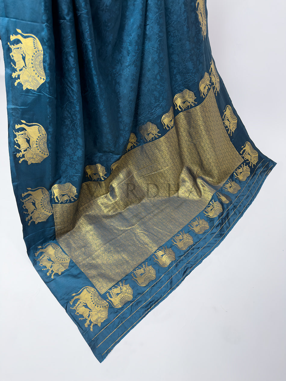 Blue saree with gold elephant patterns on a white background A high-angle shot showcasing the magnificent spread of the Midnight Blue Satin Silk Saree&