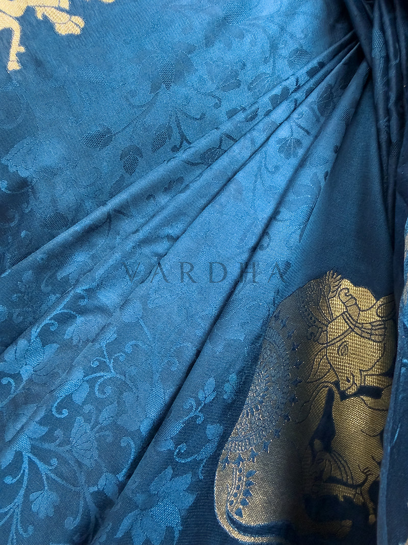 Blue fabric with gold floral patterns, featuring the brand &