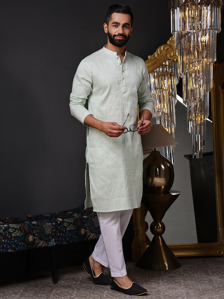 Full view of a model wearing a crisp mint green textured kurta with white pajamas
