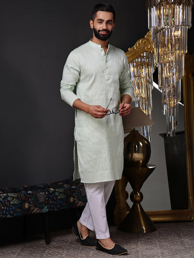 Full view of a model wearing a crisp mint green textured kurta with white pajamas
