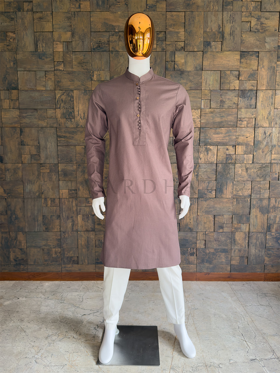 Mannequin wearing a brown kurta against a wooden paneled wall. Front view of a man wearing a House of Vardha mocha brown micro-textured cotton kurta. Elegant men's ethnic wear perfect for festive parties, pujas, and smart-casual traditional events.