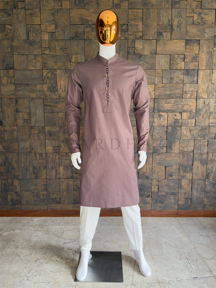 Mannequin wearing a brown kurta against a wooden paneled wall. Front view of a man wearing a House of Vardha mocha brown micro-textured cotton kurta. Elegant men&