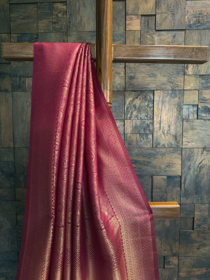 Close-up of the heavy brocade blouse fabric showing dense diamond gold zari weave.