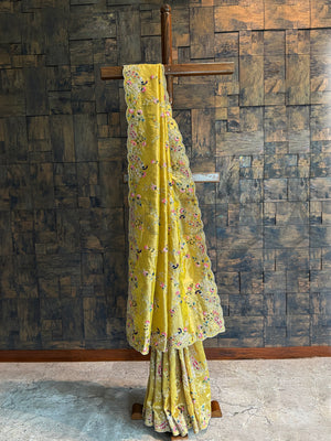 Mustard Kanjivaram tissue silk saree with floral embroidery, peacock-inspired motifs, zari, and scalloped border.