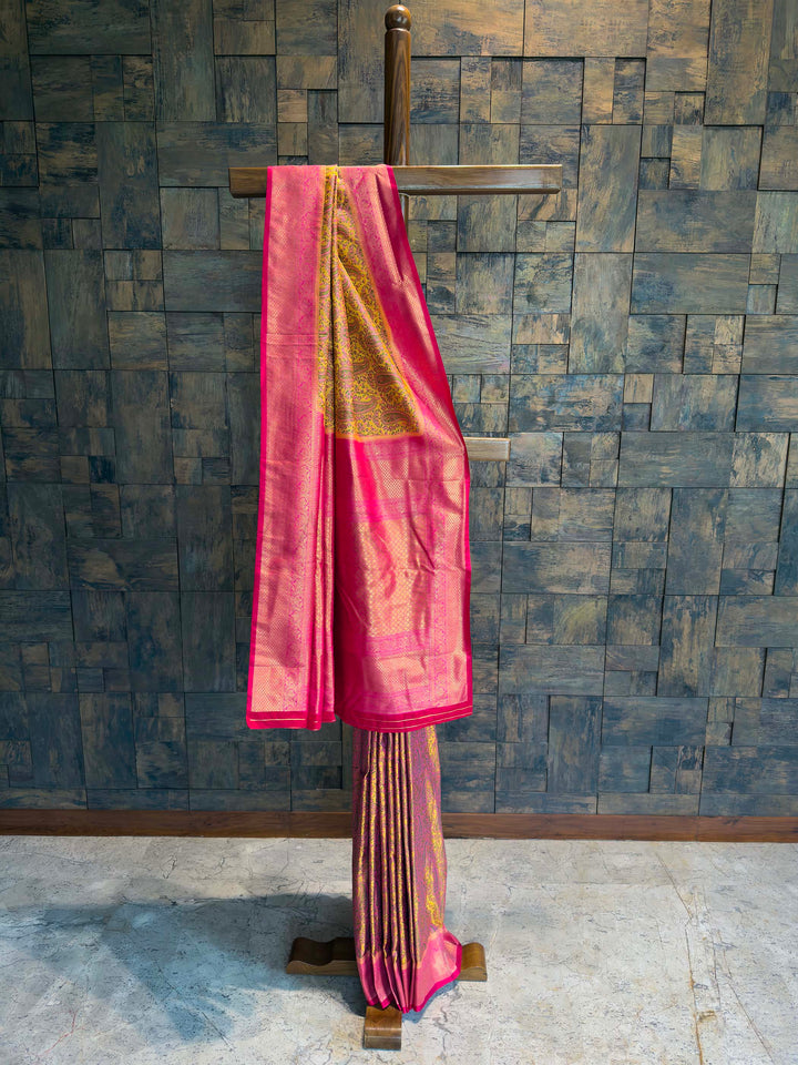 Full drape view of Mustard Yellow Tanchoi Silk saree with Pink border on mannequin.