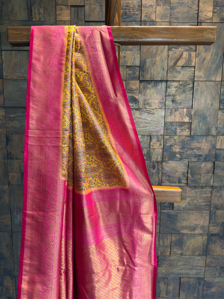 Close-up of the yellow satin body showing pink and green woven paisley motifs.