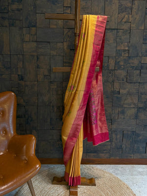 Mustard yellow kalamkari art silk saree with digital floral pallu in rani pink and golden woven border., Pleated mustard saree with zari highlights and floral kalamkari buta along side view of contrast pallu
