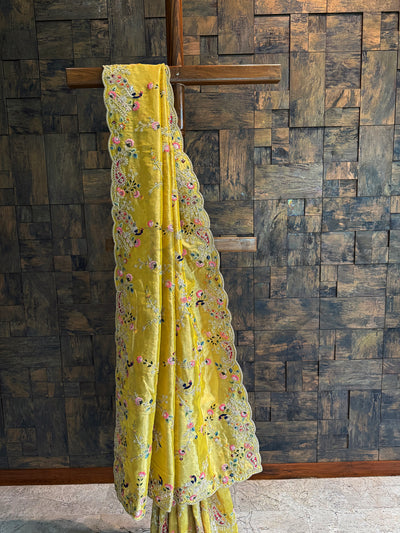 Mustard Kanjivaram saree showcasing peacock motifs, beadwork, and zari accents along luminous tissue fabric.