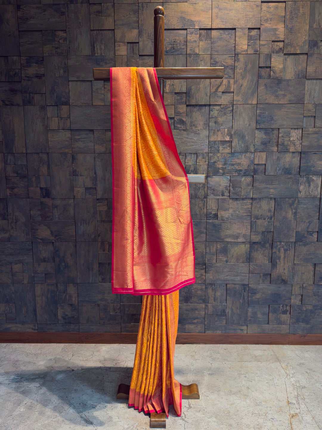 Full drape view of Ochre Yellow Tanchoi Satin Silk saree with Pink border on mannequin.