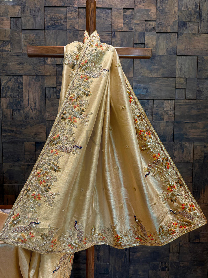 Zoomed image of the zari weaving pattern on the saree base with visible metallic luster and fine thread density. Decorative fabric with intricate embroidery on a wooden background