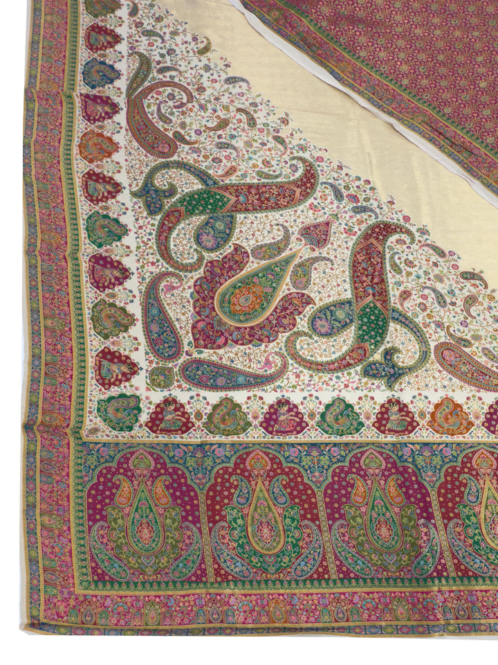 Close-up of a patterned fabric with paisley designs in red, green, and beige.