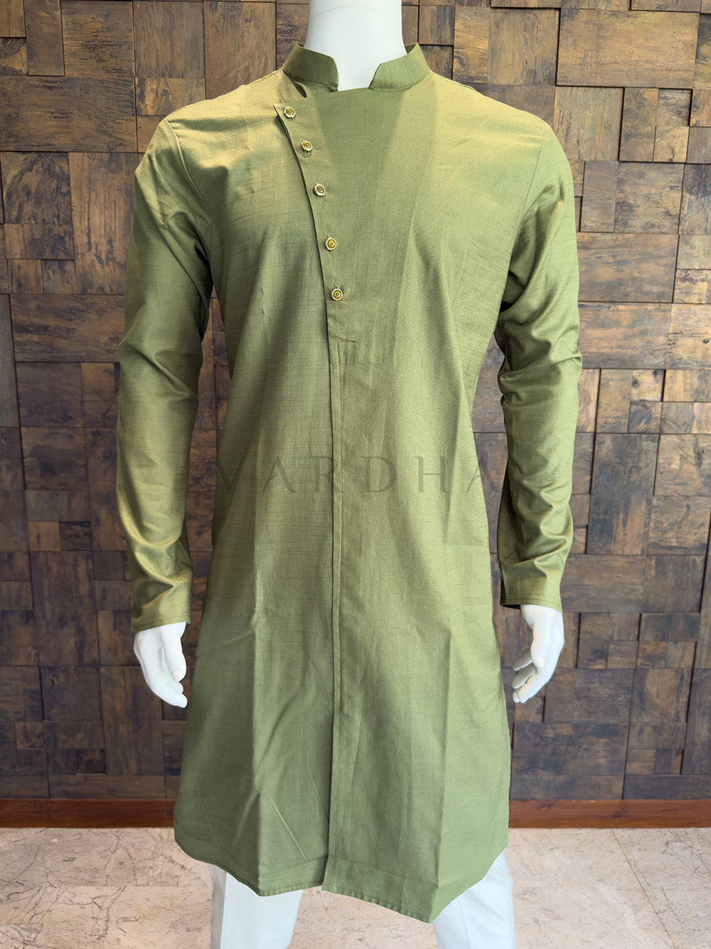 Green kurta on a mannequin against a wooden paneled wall. Close-up of the olive green kurta showcasing the modern diagonal placket and crisp mandarin collar.