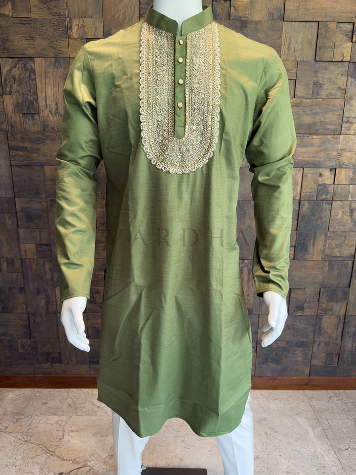 Green kurta with intricate embroidery on a wooden paneled background. Premium breathable Olive Green cotton kurta that balances a traditional royal aesthetic with high-quality, comfortable modern fabric.