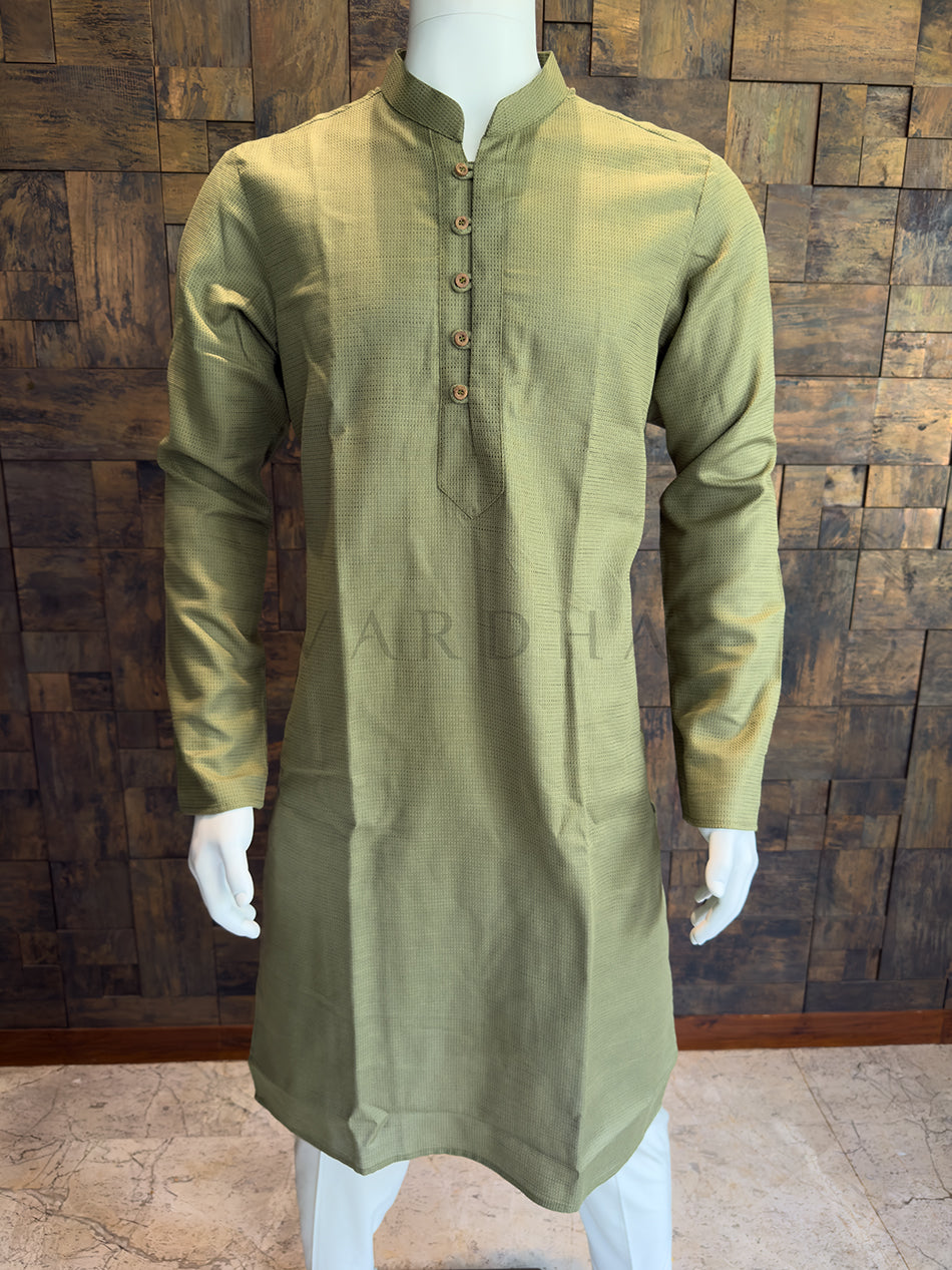 Green kurta on a mannequin against a wooden paneled wall. Close-up of a designer Olive Green kurta showing rustic, artisanal textured buttons and meticulous loop detailing on a structured placket.