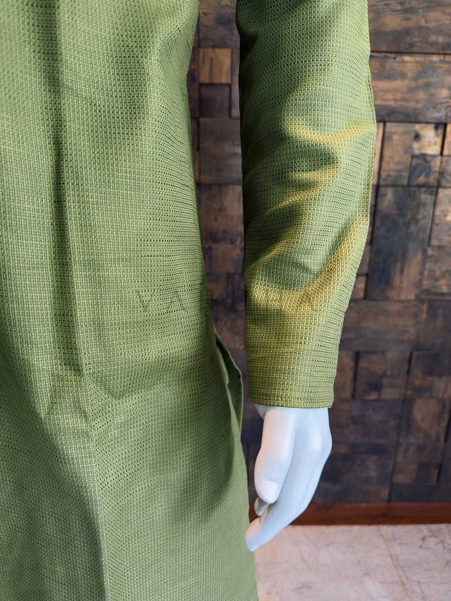 Green textured garment on a mannequin with a wooden belt against a wooden paneled wall. Premium breathable Olive Green cotton kurta highlighting the visual depth of its woven fabric and artisanal tailoring details.