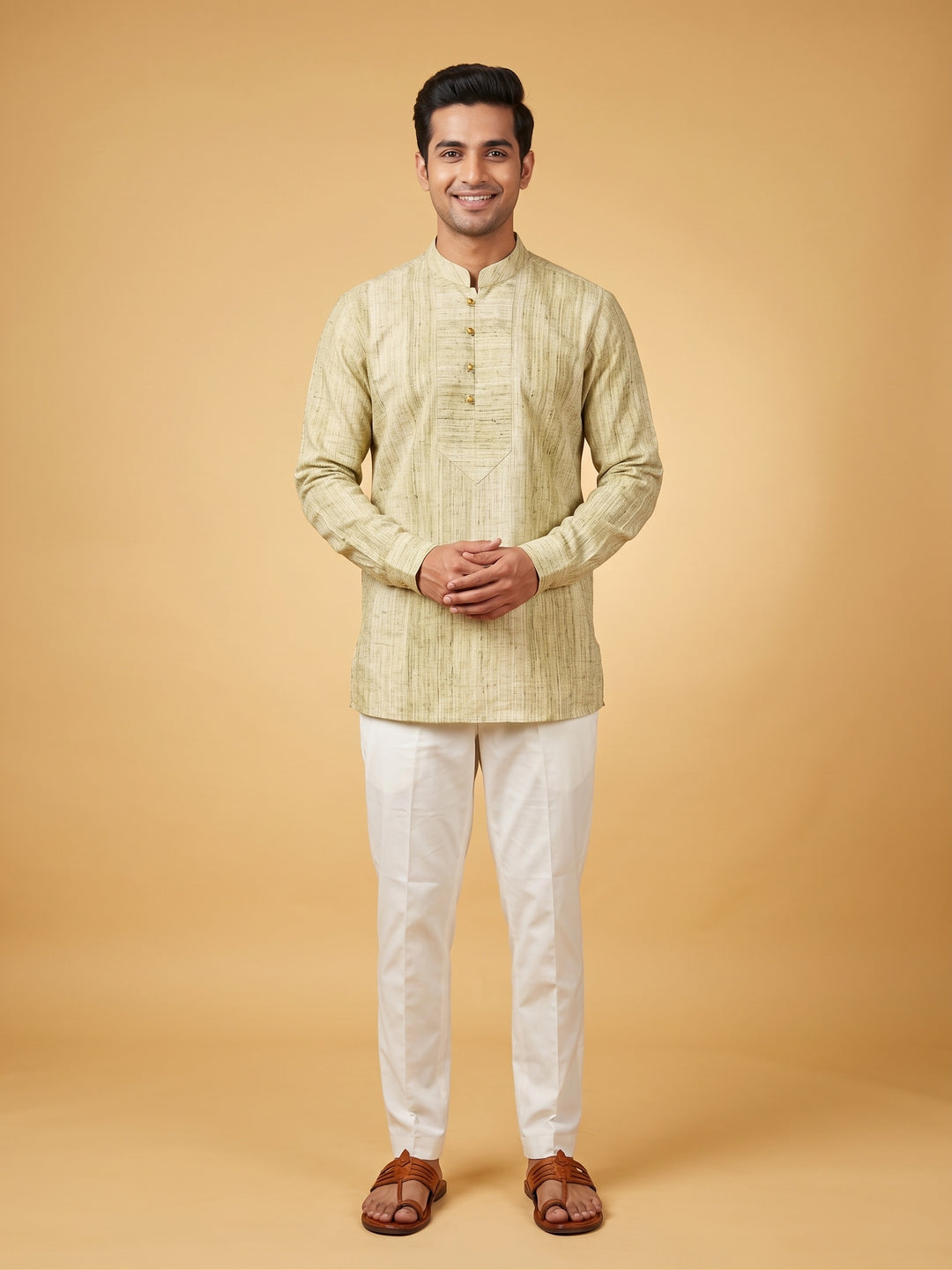 A man modeling a light beige textured kurta with a mandarin collar and white trousers, standing against a solid warm beige studio background. Full-length front view of a man wearing an olive green textured cotton short kurta with a structured placket and white trousers.