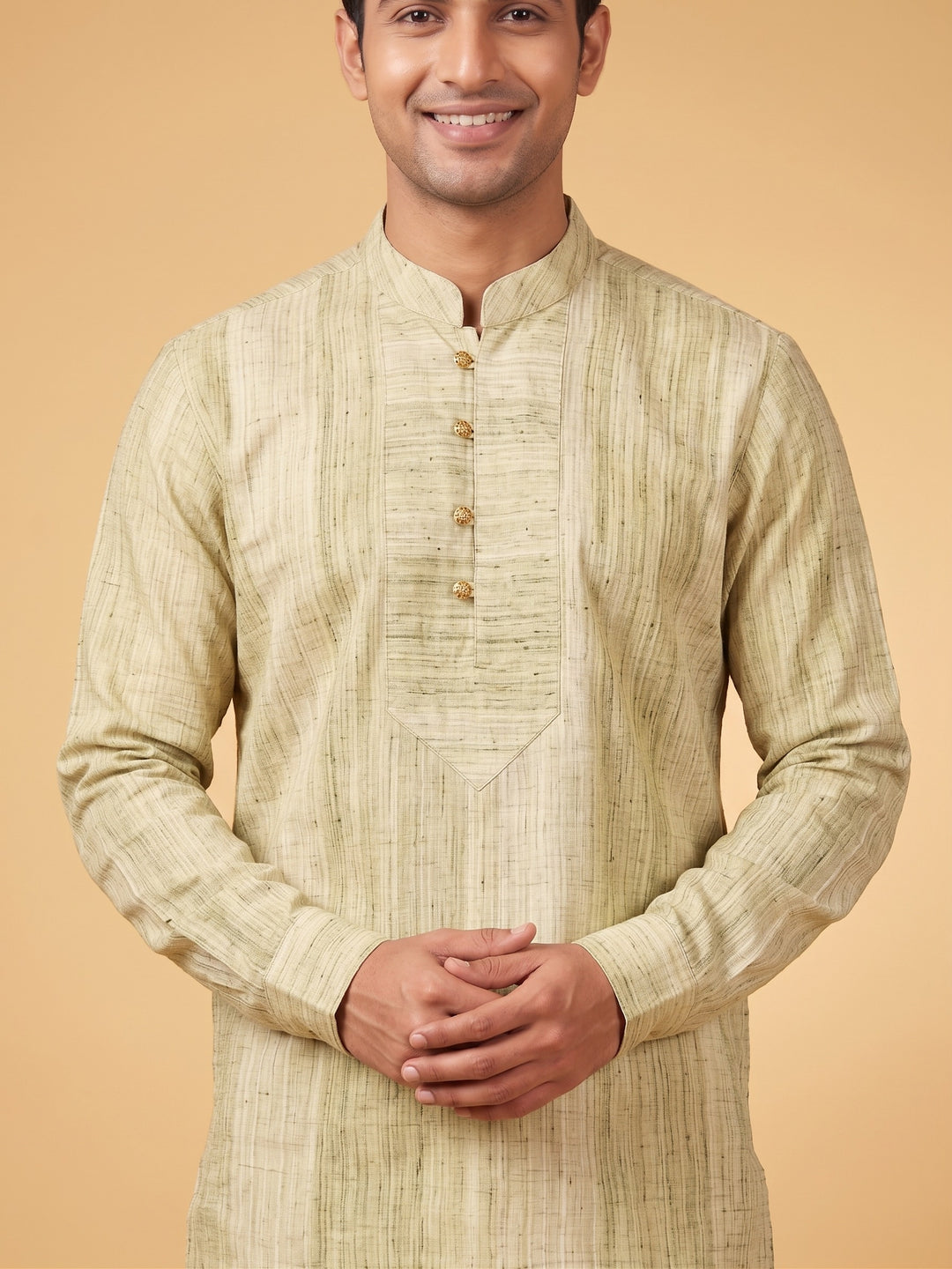 A man wearing a light beige textured kurta with a mandarin collar and three-quarter sleeves, standing against a solid beige background. Medium shot of a man modeling an olive green textured cotton short kurta with a structured placket and white trousers.